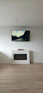 een witte woonkamer met een tv aan de muur bij Ferienwohnung Nideggen in Nideggen