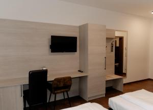 a bedroom with a desk and a tv on a wall at Ayhan Hotel in Burgdorf