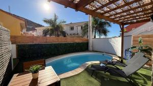 a swimming pool in a backyard with a table and chairs at Palmview Private Pool in Arguineguín