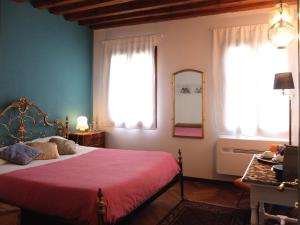 ヴェネツィアにあるB&B Le Tereseのベッドルーム1室(ベッド1台、窓2つ、鏡付)