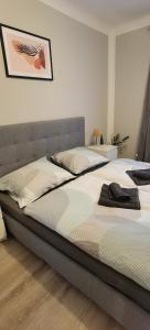 een slaapkamer met een groot bed met witte lakens bij Ferienwohnung Alexander in Niederaigen