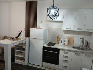 eine Küche mit einem weißen Kühlschrank und einer Spüle in der Unterkunft Apartman Mirjana in Sarajevo + 21 Fotos