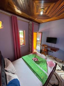 een slaapkamer met een bed met een groene deken erop bij NGK Hôtel Apartment in Bafoussam +18 foto's