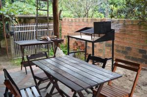 a picnic table and two tables and chairs next to a brick wall at Casa de huéspedes Aruska in São Gabriel