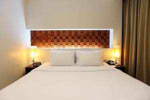 a bedroom with a large bed with two pillows at The Album Hotel in Patong Beach