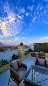 a patio with chairs and a table on a roof at Makan Pyramids Hotel in Cairo