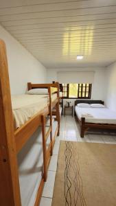 una camera da letto con tre letti a castello in una stanza di Casa da Índia - Pousada Jussara a Joinville