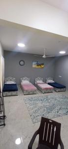 Mawāliḩmandegar guest house的房间里有四张床和一把椅子。