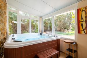 a large bath tub in a room with windows at Es Marroig Villa y Spa in Llucmajor