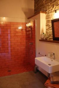 une salle de bains avec une douche en briques rouges et un lavabo dans l'établissement Cascina Zan, à Paroldo