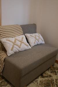 een bank in een kamer met twee kussens erop bij VIELA Guest House T2 in Barcelos