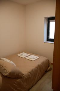 een slaapkamer met een bed met twee handdoeken erop bij VIELA Guest House T2 in Barcelos +12 foto's
