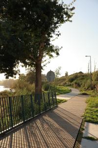 een hek naast een stoep met een boom bij VIELA Guest House T2 in Barcelos