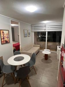 een woonkamer met een bank, een tafel en stoelen bij Departamento claro solar in Temuco