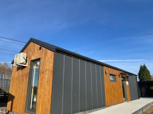 een huis met een buitenkant van metaal en hout bij Pochyła 80 home&spa in Rybnik +5 foto's