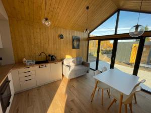 een keuken en woonkamer met een tafel en stoelen bij Pochyła 80 home&spa in Rybnik