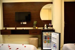 a room with a television and a small refrigerator at Makan Pyramids Hotel in Cairo