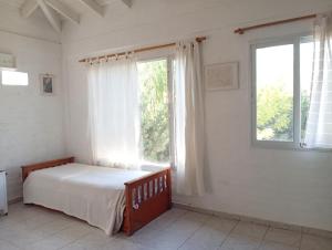 a bedroom with a bed and a large window at Casa Boreal dptos estilo casa in Puerto Madryn