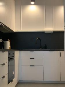 a kitchen with white cabinets and a sink at Moon Deer in Jelenia Góra