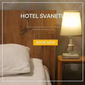 een hotelkamer met een bed en een lamp op het nachtkastje bij Hotel Svaneti in Mestia