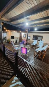 un ponte con sedie, un tavolo e un camino di Casa do Rabelo a Balneário Gaivotas