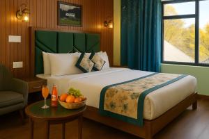a bedroom with a bed and a table with a bowl of fruit at The Frozen Leaf in Pahalgām