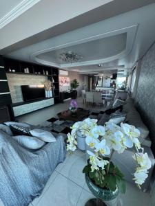 a living room with a couch and flowers in a room at Cobertura Beira Mar in Capão da Canoa