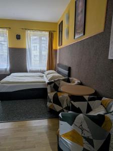 a room with two beds and a table and a couch at Ubytování u Kováře in Ústí nad Labem