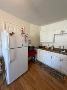 een keuken met een witte koelkast en witte kasten bij Florida Room in Lehigh Acres