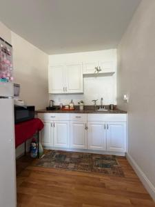 een keuken met witte kasten en een houten vloer bij Florida Room in Lehigh Acres