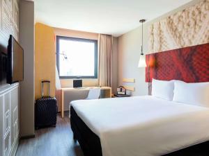 a hotel room with a large bed and a window at ibis Tijuana in Tijuana