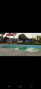 een foto van een zwembad met een parasol bij Chacara do Araujo in Mogi das Cruzes +3 foto's