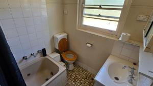 une salle de bains avec toilettes, baignoire et lavabo dans l'établissement Griffin lakeside, à Yarralumla