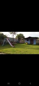 twee foto's van een speeltuin met een glijbaan bij Chacara do Araujo in Mogi das Cruzes