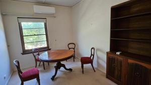 une salle à manger avec une table et des chaises et une fenêtre dans l'établissement Griffin lakeside, à Yarralumla