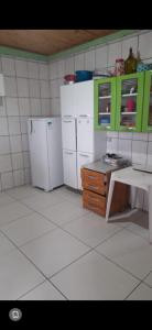 een keuken met witte apparaten en groene kasten bij Chacara do Araujo in Mogi das Cruzes