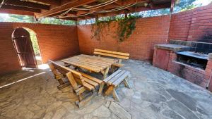 une table en bois et deux bancs dans une pièce en briques dans l'établissement Griffin lakeside, à Yarralumla