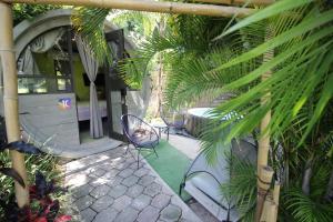 eine Terrasse mit zwei Stühlen, einem Tisch und Palmen in der Unterkunft kubhotel in Tlaquiltenango