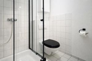 ein Bad mit einem schwarzen WC und einer Dusche in der Unterkunft Studio am Malerweg Altstadt Pirna in Pirna + 19 Fotos