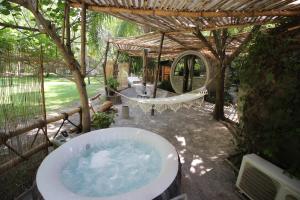 eine Badewanne in einem Garten mit einem Baum in der Unterkunft kubhotel in Tlaquiltenango