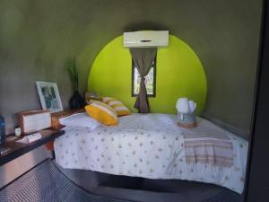 ein Schlafzimmer mit einem Bett und einer grünen Wand in der Unterkunft kubhotel in Tlaquiltenango