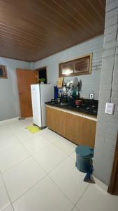 a kitchen with a sink and a refrigerator at Chalé Sol e Luar 3 Ambientes in Santo Amaro