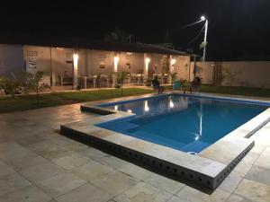 a swimming pool in a yard at night at Chalé Sol e Luar 3 Ambientes in Santo Amaro