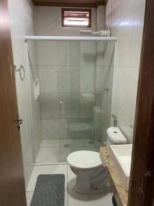 a bathroom with a shower with a toilet and a sink at Chalé Sol e Luar 3 Ambientes in Santo Amaro