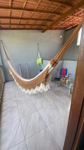 a hammock in a room with a table at Chalé Sol e Luar 3 Ambientes in Santo Amaro