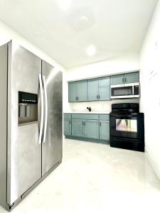a kitchen with blue cabinets and a stainless steel refrigerator at 2 bedroom 2467 in Miami