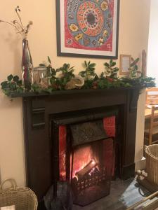 ein Kamin mit einem Weihnachtskranz darauf in der Unterkunft Trigonos - Peaceful Lakeside B&B and Retreat in Eryri National Park in Caernarfon