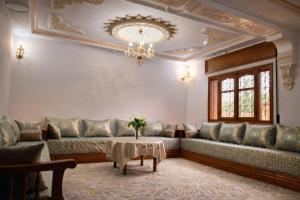 a living room with couches and a chandelier at Villa abdo in Asilah