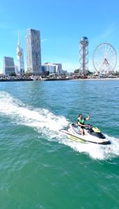 un homme faisant du jet ski dans l'eau dans l'établissement Three Lion Hotel, à Batoumi