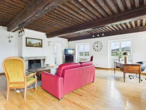 a living room with a red couch and a table at Séjourner au Château de la Roue Grand appartement in Lissieu
